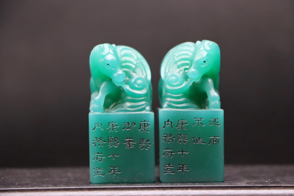 A pair of seals featuring yellowish-green jade and a galloping horse